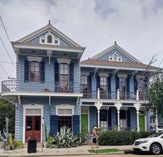 a car parked in front of a blue two story house