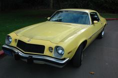 a yellow car is parked on the street