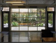 the inside of an office building with lots of glass doors and tables in front of them