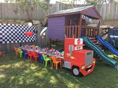 a party table set up in the backyard with cars and race cars decorations on it