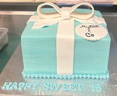 a blue cake with white ribbon and bow on top that says happy sweet 16 th birthday