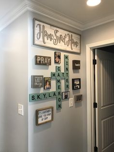 a wall filled with lots of different types of framed pictures and words on the wall