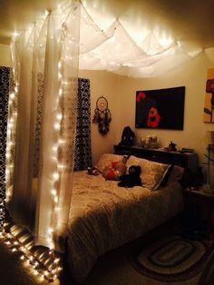 a bed with lights on the headboard and canopy over it