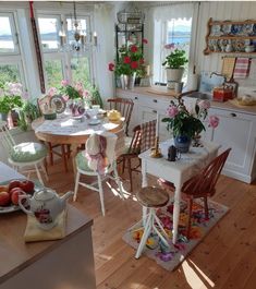 a kitchen filled with lots of furniture and flowers in vases on top of the table