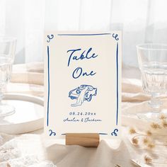 a place card sitting on top of a table next to wine glasses and silverware