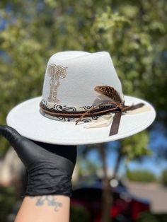 Please reach out to me  for a consultation on a custom, one of a kind hat that is the perfect accessory for any casual day, photo shoot or special occasion. Each hat is burned with any custom design and comes with a signature leather band. Send me a message today to bring your idea to life! Custom White Fedora For Country Events, White Western Fedora With Flat Crown, White Fedora With Flat Crown For Country Events, Custom White Handmade Fedora, Custom Handmade White Fedora, White Handmade Fedora For Rodeo, Handmade White Fedora For Rodeo, Western Style White Top Hat With Flat Crown, Artisan White Hat Bands For Western-themed Events