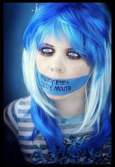 a woman with blue hair has her face taped to the side and is wearing a mask