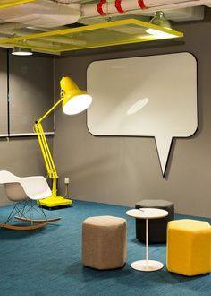 a yellow lamp sitting on top of a table next to a white chair and ottoman