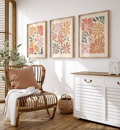 three framed art prints hang on the wall above a white dresser and sideboard in a room with wood flooring