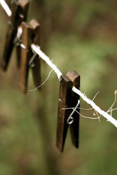 several pieces of wood are hanging on a line with barbed wire in the foreground