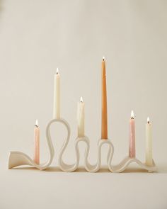 five candles are lined up in the shape of an x, with one candle on each side