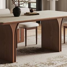 a dining room table with two chairs and a vase