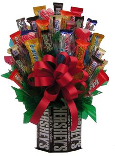 a bouquet of candy and candies in a box with a bow on the top