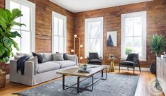 a living room filled with furniture and wooden walls