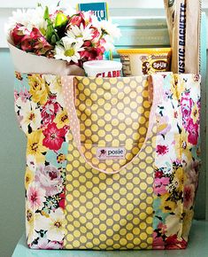 a flowered bag sitting on top of a counter next to some books and magazines