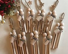 a bunch of wooden clothes pins with bows on them next to a christmas tree ornament