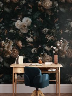 a desk with a chair and flowers on it in front of a wallpapered background