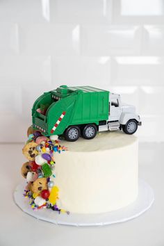 a cake with a green truck and teddy bears on top