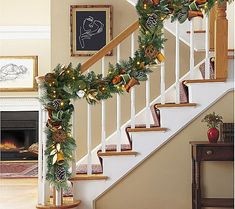 christmas decorations on the banisters and stairs are decorated with pine cones, evergreen leaves