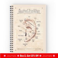 a spiral notebook with an illustrated diagram of the parts of a human ear on it