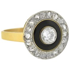 A very striking diamond ring from the Edwardian (ca1901) era! This gorgeous mixed metals design is crafted in 18kt gold and topped in platinum. The flat, circular centerpiece features a sparkling old Mine Cut diamond at the center, which weighs approximately .50ct and has estimated H color and VS2 clarity. The diamond is held within a milgrained bezel, and surrounded by a solid black enameled border. The rich, glossy black enamel is the perfect compliment to the sparkling diamond halo, which is 1910s Engagement Ring, Purple Sapphire Ring, Sunburst Ring, Edwardian Engagement Ring, Victorian Engagement Rings, Edwardian Ring, Art Deco Engagement, Sparkling Diamond, Yellow Gold Engagement