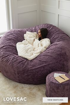 a woman laying in a bean bag chair with the text love sac $ 100 off for every $ 240 spent