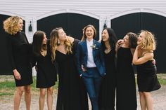 a group of young women standing next to each other in front of a white building