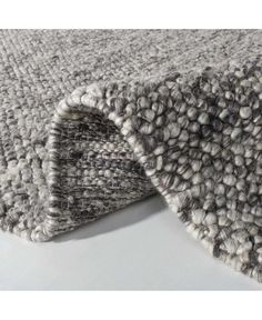 a close up view of a rug on a white surface with grey and gray colors