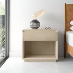 a bedroom with a bed, nightstand and window