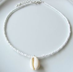 Shell Choker White Choker Necklace White Beaded Choker Summer Necklace Sea Choker Beach Jewelry Dainty and elegant all white beaded choker with glass tiny seed beads and a real shell pendant. DESCRIPTION Made from 2mm glass seed beads and closes with a silver plated clasp and 2 inches adjustable chain. SIZE Necklace is 13 inches and can be adjusted up to 15 inches with a 2 inches extender chain. Shell is around 1 inch long or 2.5 cm. Please let me know if you would like a different length. WRAPP White Beaded Shell Necklace With Round Beads, Adjustable Beaded White Shell Necklace, White Beaded Strand Beads, White Beaded Shell Necklace In Strand Shape, White Tiny Beads Strand, Handmade White Jewelry For Beach Wedding, White Beaded Necklaces With Colorful Beads For Weddings, White Beaded Necklace With Colorful Beads For Weddings, White Beaded Jewelry For Beach Wedding