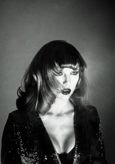 a black and white photo of a woman with long hair wearing a sequin jacket