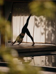 a person doing a handstand in front of a pool