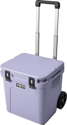 the yeti wheeled cooler is purple and has wheels on each side with two handles