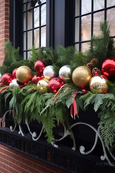 a window box filled with christmas ornaments and greenery