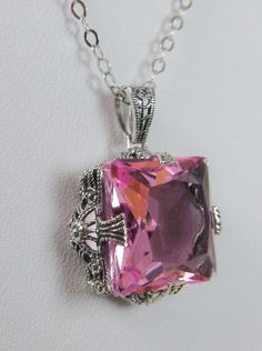 Simulated Pink Topaz Solid Sterling Silver Pendant Necklace Square Vic Design#P77 This is a stunning Victorian inspired pendant necklace that is hand crafted in solid sterling silver. This necklace has a 10-carat simulated pink topaz gemstone. The gemstone is a flawless man-made gem with a lovely pink color. The square radiant-cut gemstone is 15mm square. The entire pendant is 1-1/16" long. The 1.5mm chain, if chosen, is adjustable from 18" to 20". The pendant and chain are marked 925 for sterli Filigree Pendant Necklace, Filigree Necklaces, Topaz Pendant, Filigree Pendant, Pink Topaz, Square Pendant, Sterling Silver Filigree, Sterling Silver Necklace Pendants, Victorian Jewelry