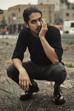 a man sitting on the ground holding his hand to his face