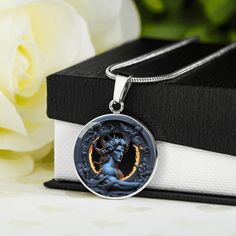 a necklace with an image of a woman in the center on it next to a white rose