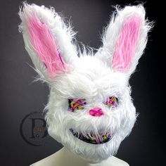 a white bunny mask with pink ears on top of a mannequin's head