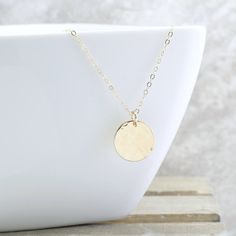 "Give her the MOON! The peacefulness of the moon is captured in this hammered gold disc necklace, and it is the perfect addition to your collection. And the perfect gift for the woman who has everything. She will NEVER take it off! Gorgeous rich 1/2\" (13mm) 14k gold fill disc is lightly hammered to create a unique textured look... every single one will be slightly different. This hangs from a 1.6mm gold filled cable chain to complete the look. It can be worn alone, or layered with other pieces Delicate Chain Coin Necklace For Gift, Gift Coin Necklace With Adjustable Chain, Adjustable Chain Coin Necklace As Gift, Hammered Round Disc Coin Necklace As Gift, Circle Moon Charm Necklace For Gift, Coin Necklace With Moon Charm As A Gift, Dainty Hammered Coin Necklace As Gift, Minimalist Hammered Coin Necklace As Gift, Gold Coin Necklace With Moon Phase For Gift