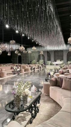 a room filled with lots of couches and chandeliers hanging from the ceiling