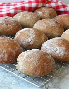 a bunch of doughnuts that are sitting on a wire rack in front of a red and white checkered napkin