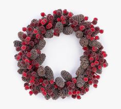 pine cones and red berries are arranged in the shape of a wreath on a white background