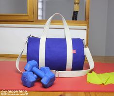 a gym bag and some dumbs on a mat