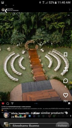 an aerial view of a wedding venue with white chairs and flowers on the aisle, surrounded by greenery