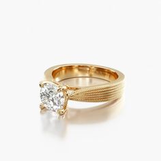 a yellow gold ring with a single diamond in the center, on a white background