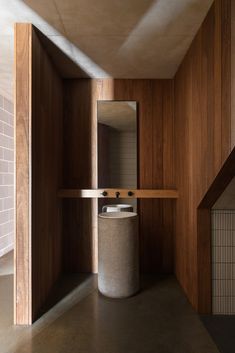 a bathroom with wooden walls and flooring next to a sink in a room that has wood paneling on the walls