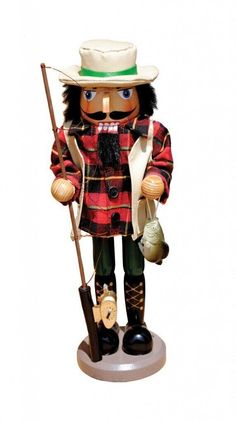 a wooden nutcracker with a fishing rod and hat