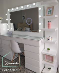 a white vanity with lights on it and a chair