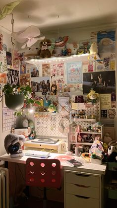 a cluttered desk with lots of pictures on the wall