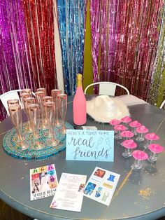 a table topped with lots of glasses filled with champagne and confetti next to a sign that says, there's toast to my real friends